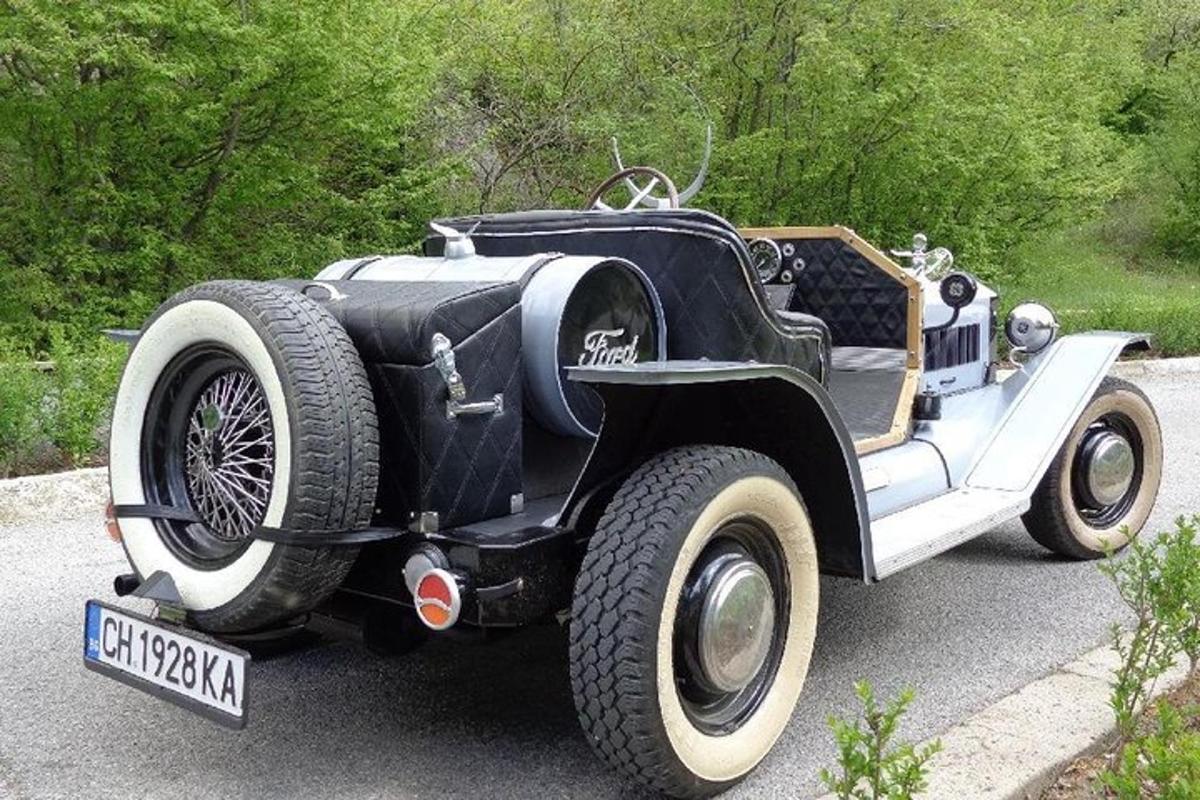 an old black and white car parked on the street