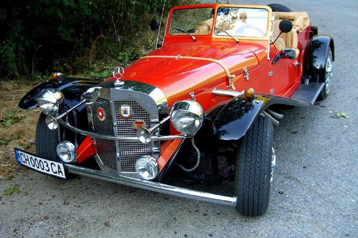 an old red car is parked on the road