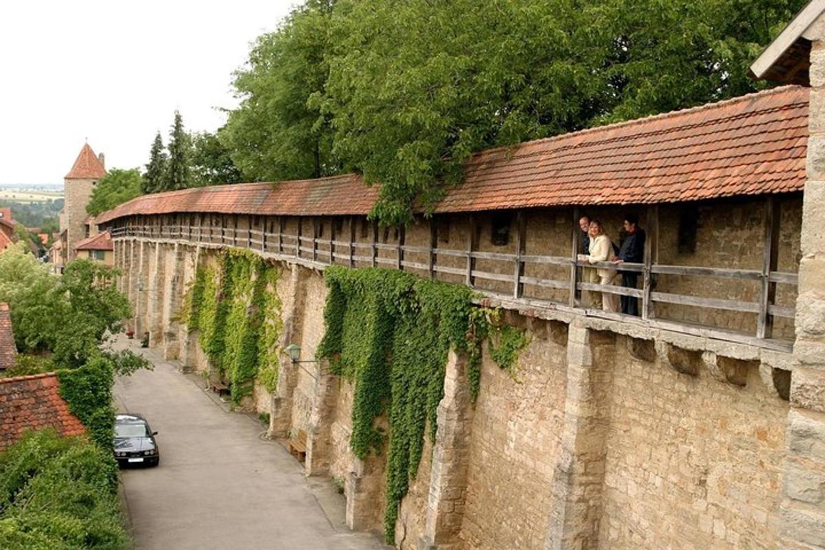 two people standing on a balcony of a wall