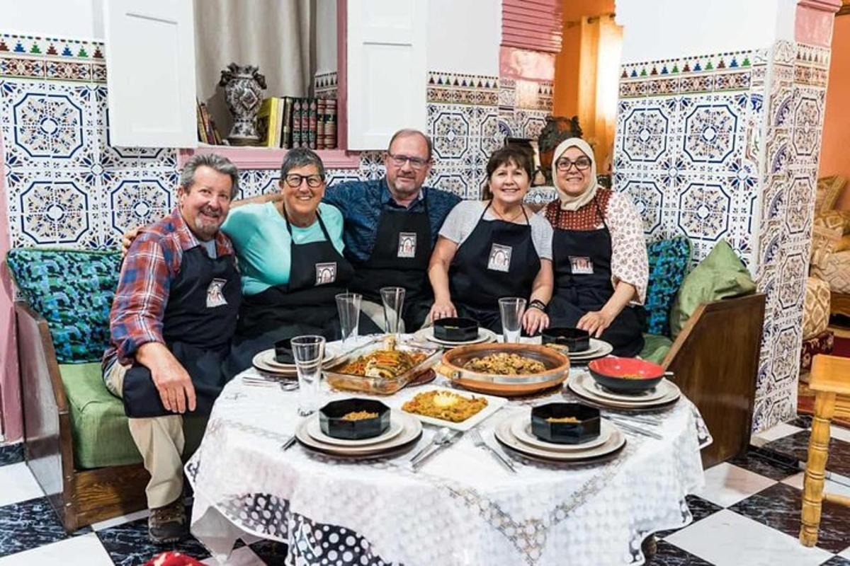 um grupo de pessoas sentadas ao redor de uma mesa com comida