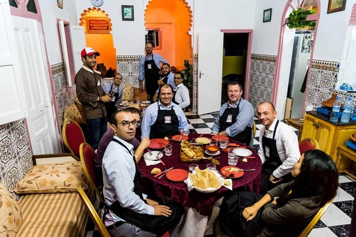 skupina lidí sedících kolem stolu s jídlem