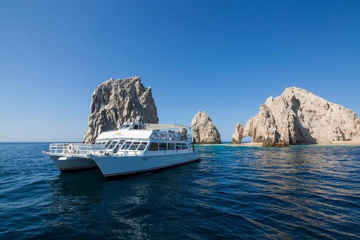 Un barco en el agua con rocas al fondo.