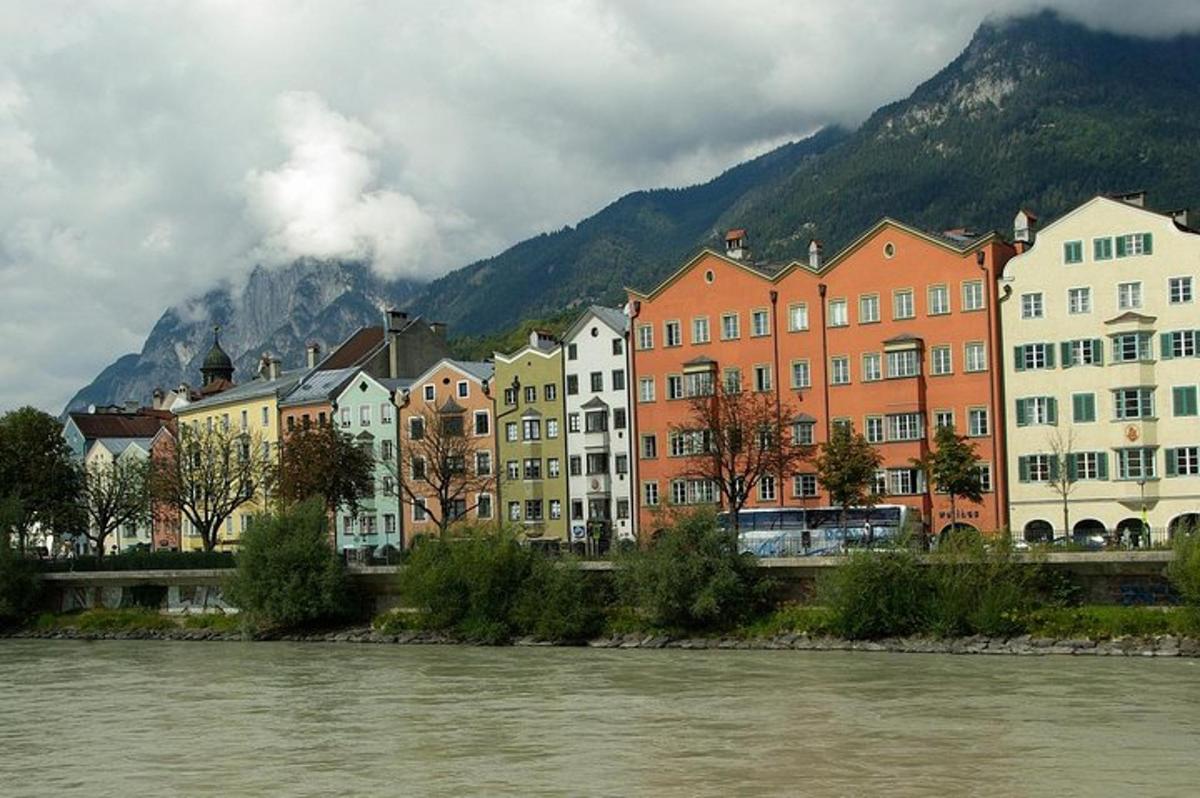 eine Gruppe von Gebäuden neben einem Fluss mit einem Berg