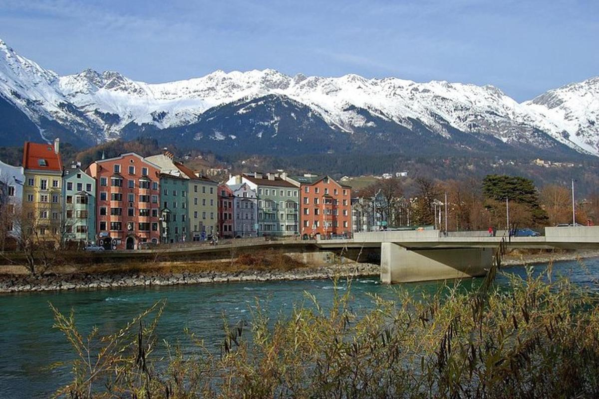 eine Brücke über einen Fluss mit schneebedeckten Bergen