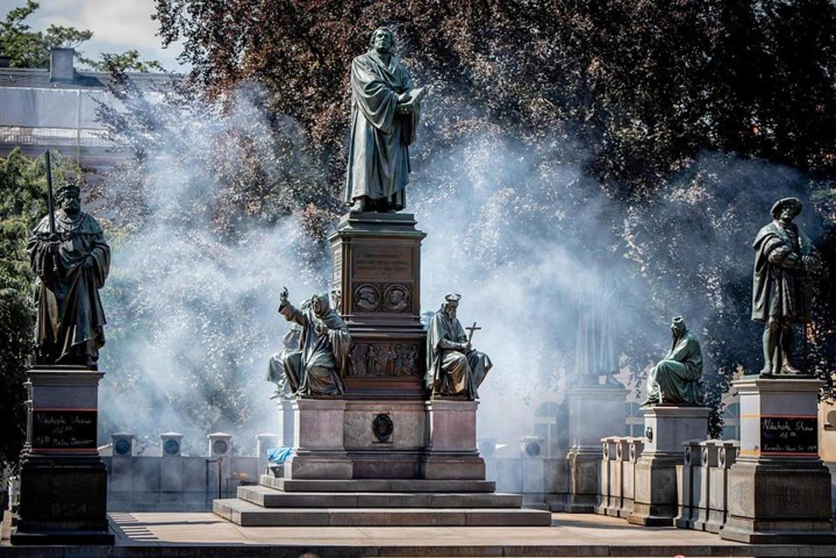 a statue in front of a fountain with statues