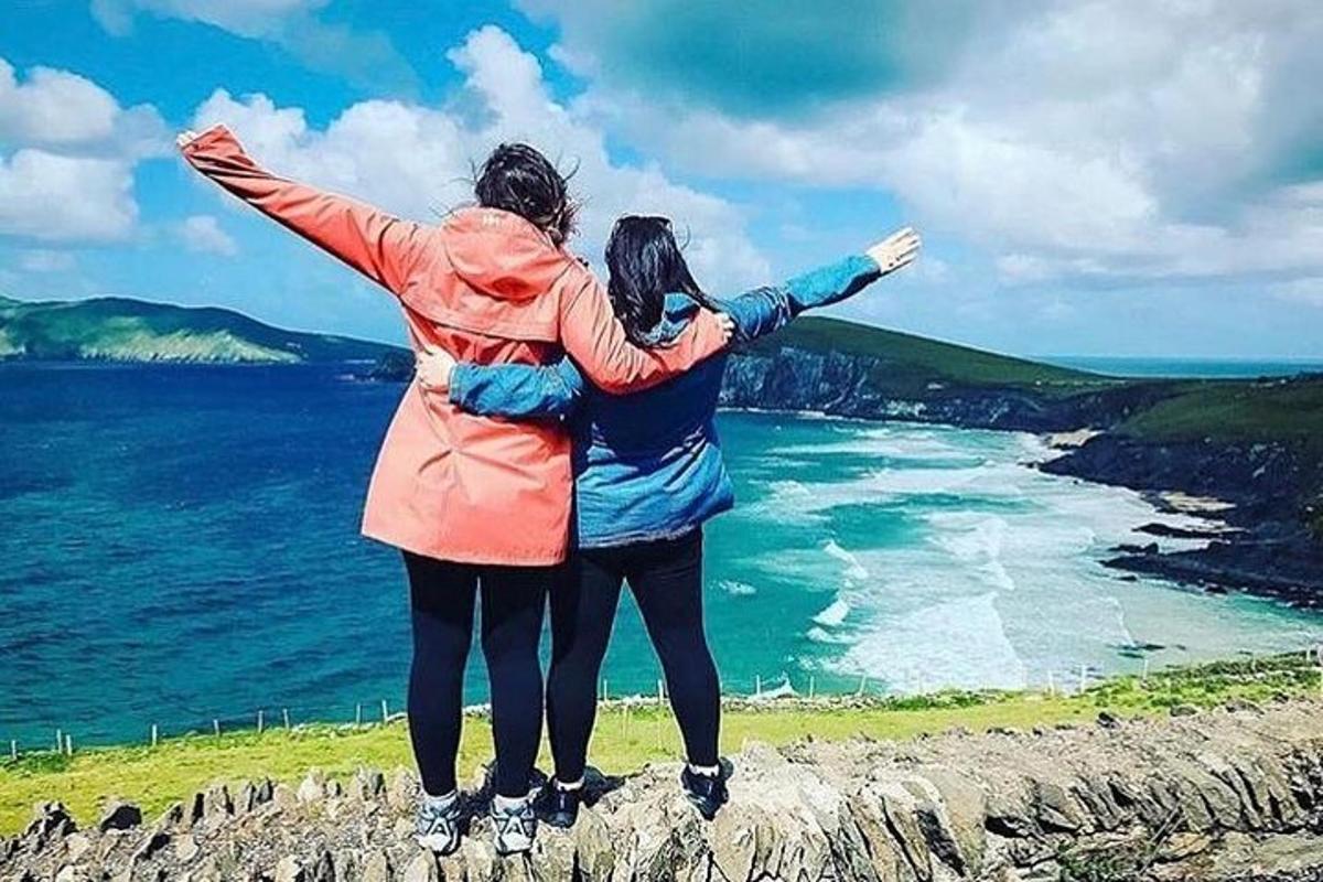 duas pessoas em pé sobre uma rocha com vista para o oceano