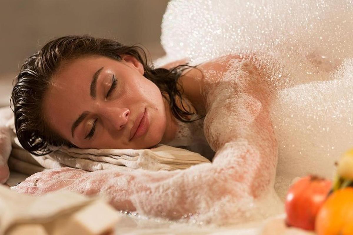 eine Frau, die in einer mit Schaum bedeckten Badewanne liegt