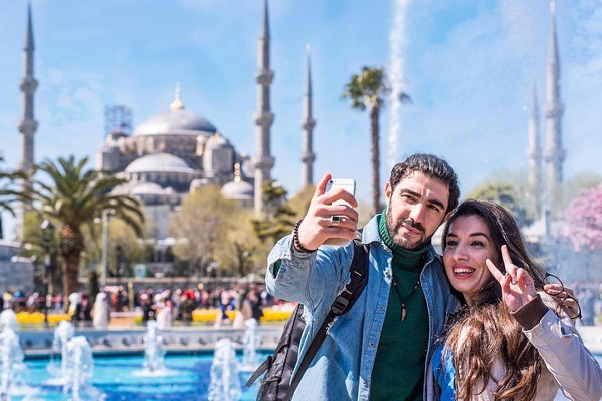 a man and a woman taking a picture in front of a fountain