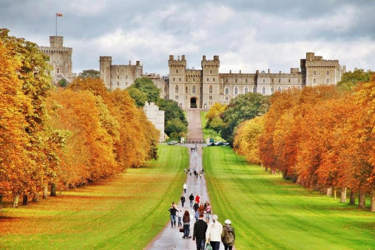 um grupo de pessoas caminhando por um caminho em frente a um castelo