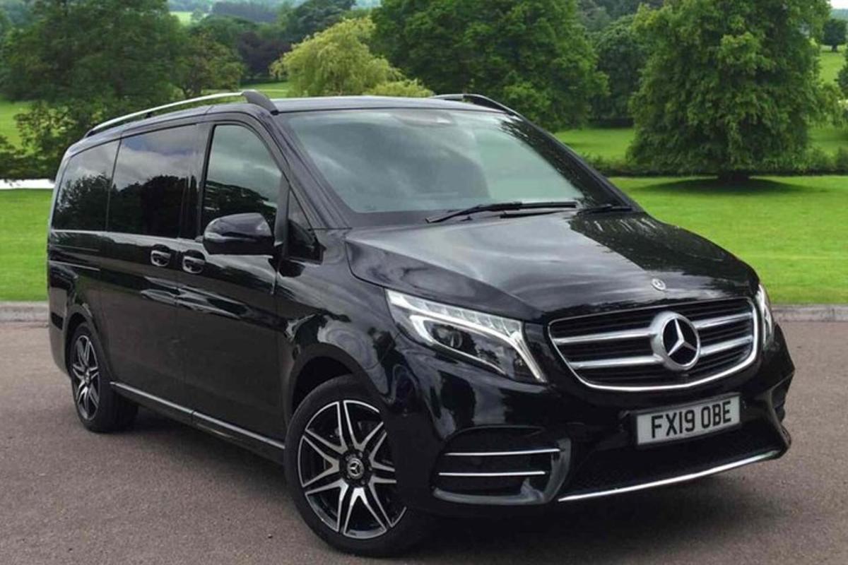 Svartur Mercedes Benz sendibíll lagður á bílastæði