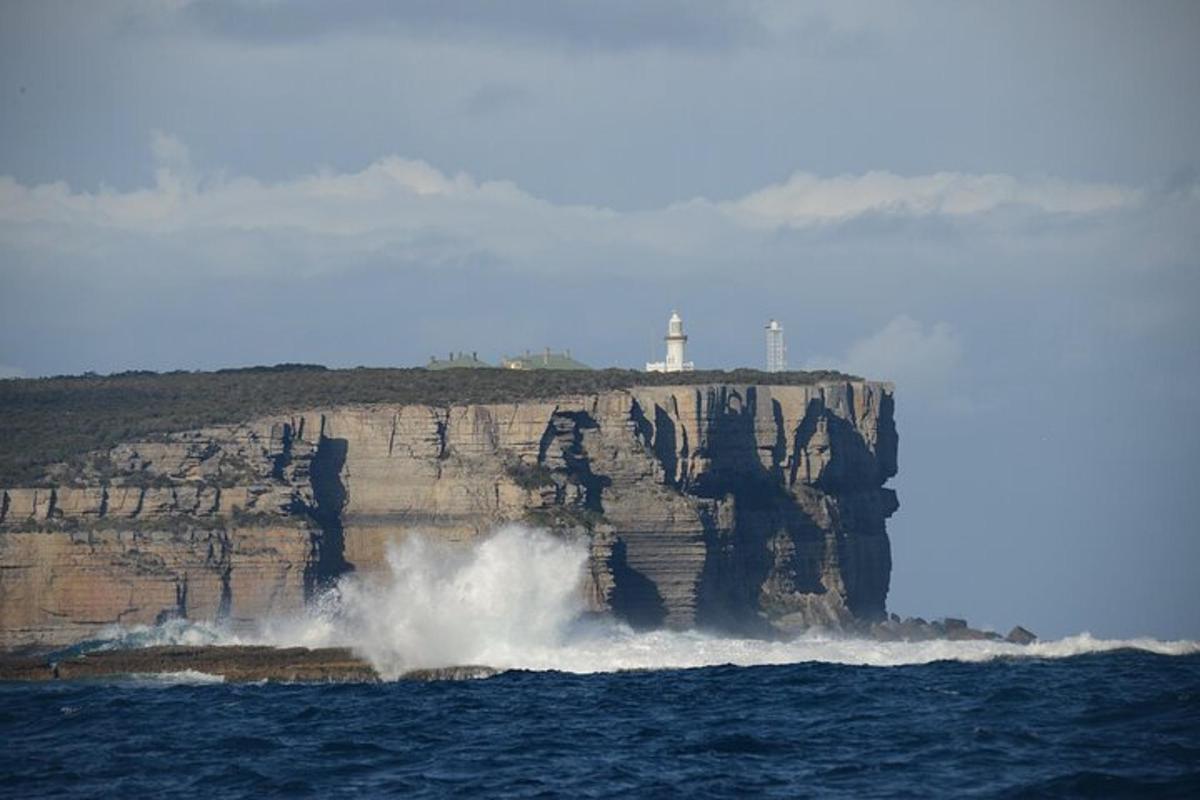 a large wave crashing on a cliff in the ocean