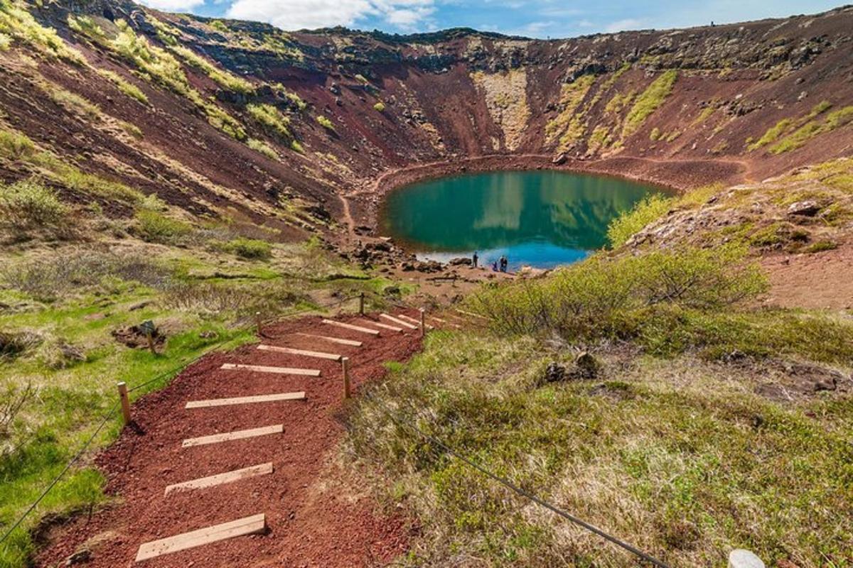 una escalera que sube por una montaña hasta un lago