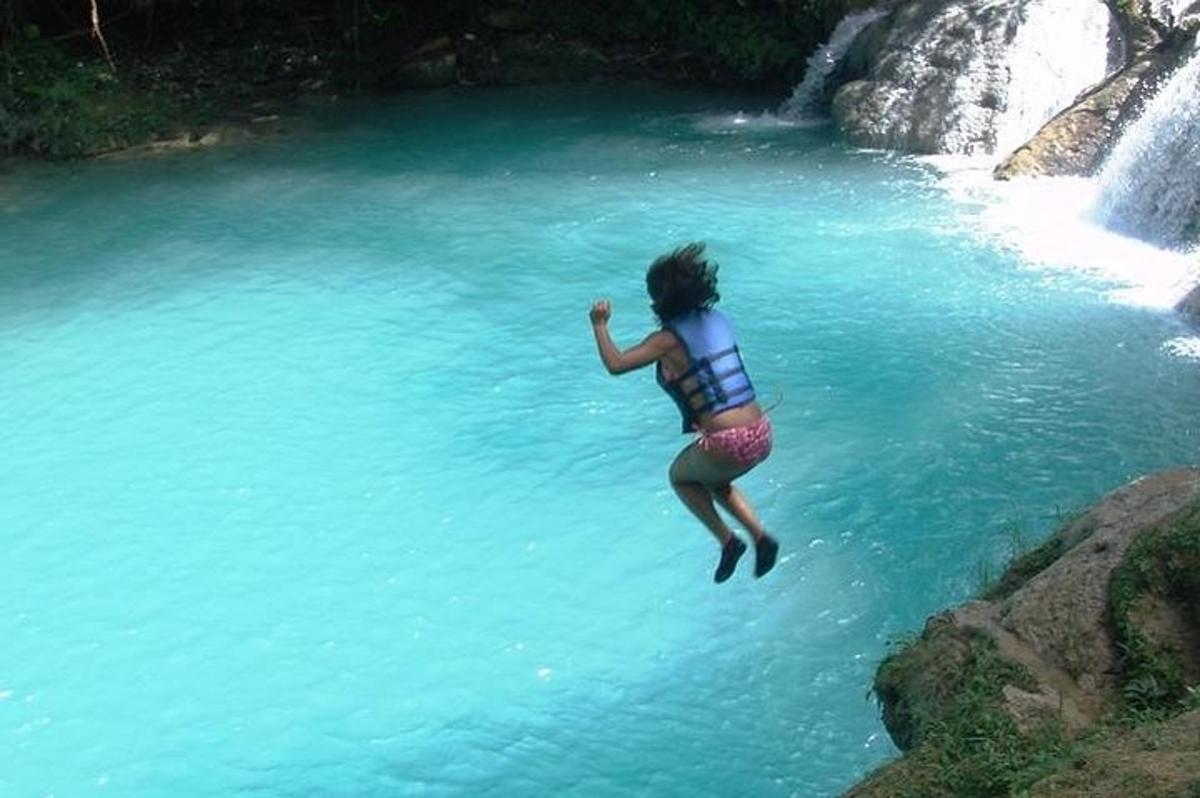 una mujer saltando a un cuerpo de agua