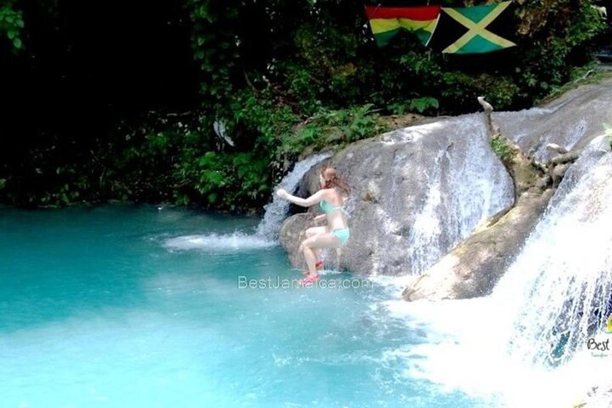 Una mujer parada sobre una roca en una cascada