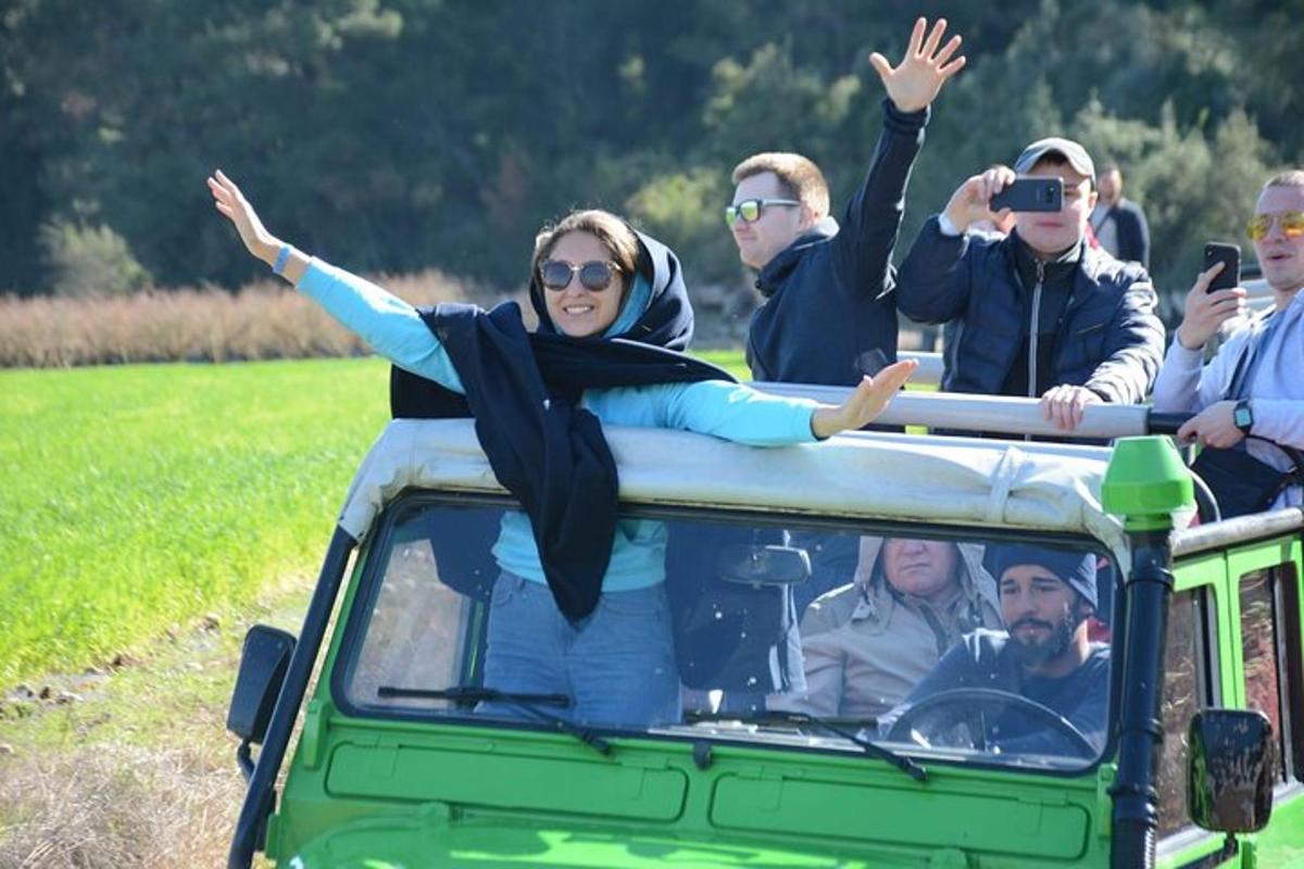 a woman sitting on the roof of a vehicle with her arms up