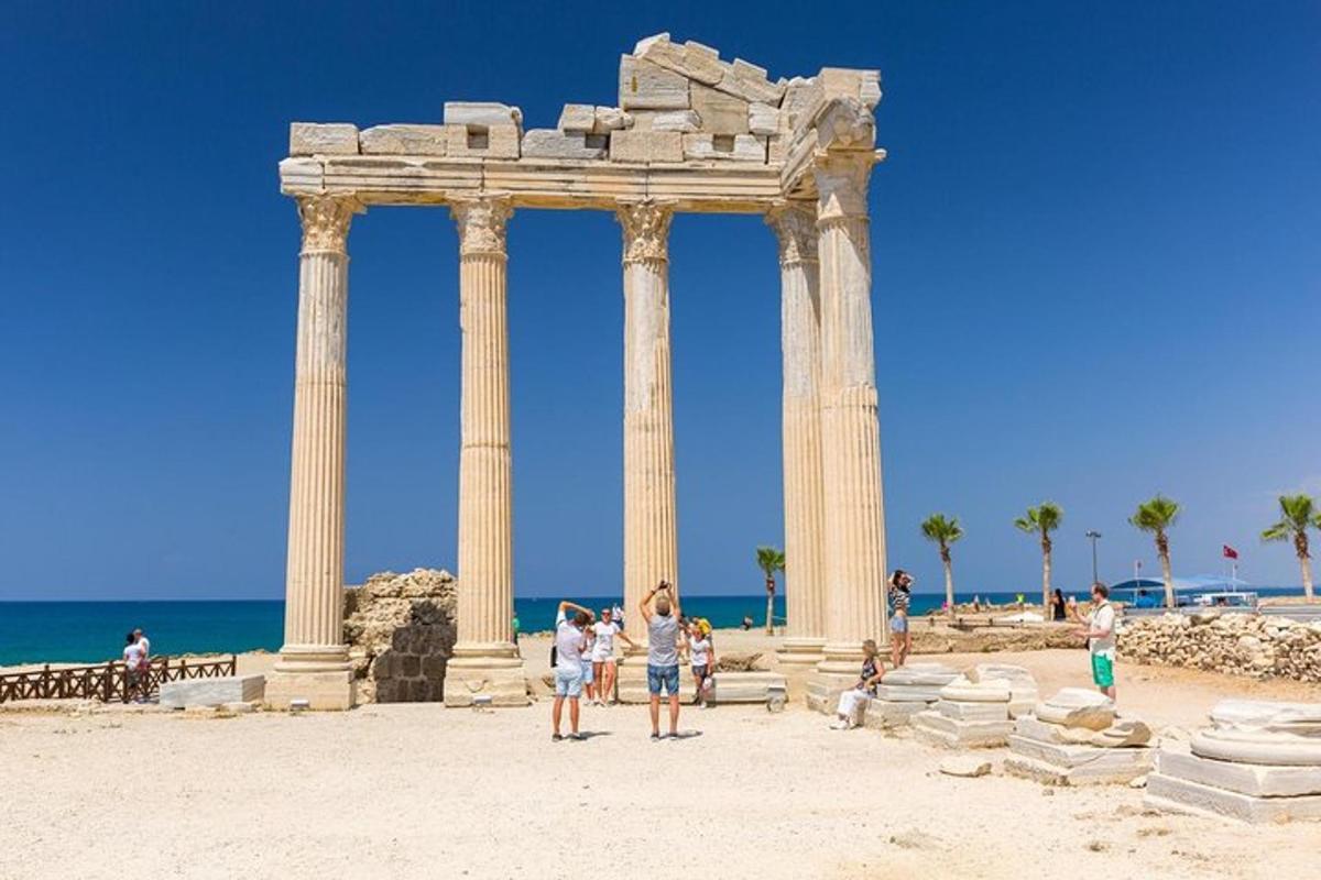 Un grupo de personas de pie frente a un templo en la playa.