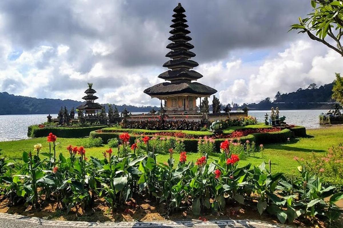 a garden with a pagoda in the middle of the water with flowers