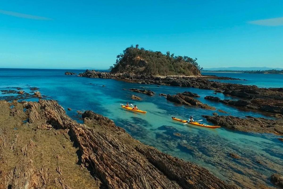 a group of boats in the water near a rocky island