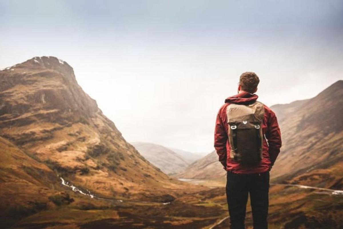 a man standing on top of a mountain looking at a valley