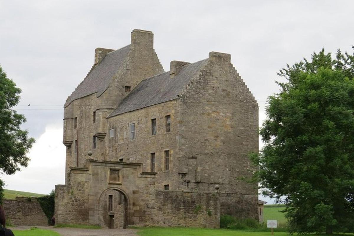 an old stone building in the middle of a field