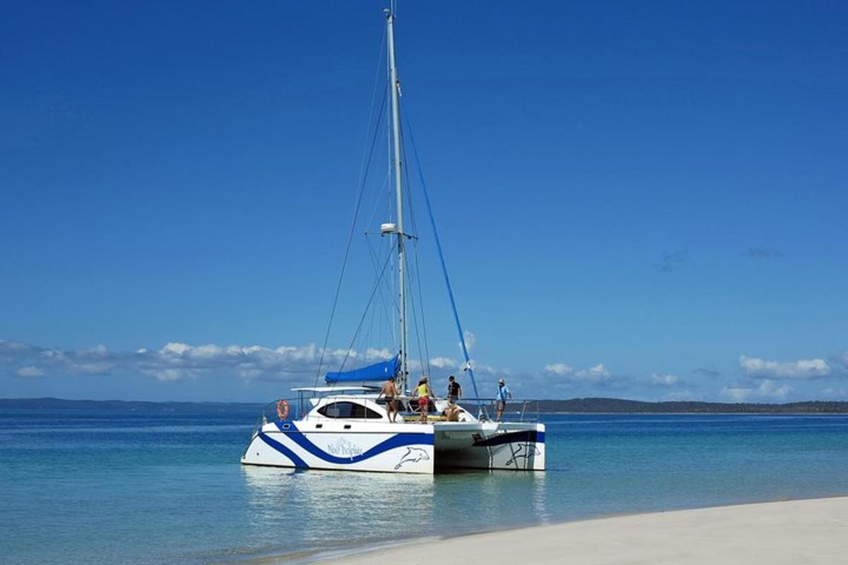 a boat floating in the water next to a beach