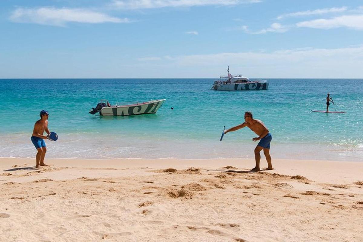 due uomini che giocano con un frisbee sulla spiaggia