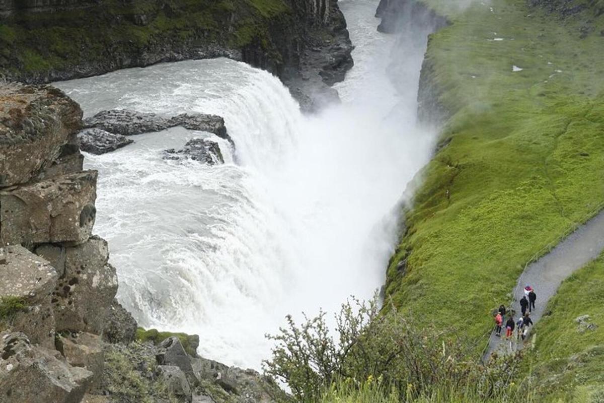 orang yang berdiri di hadapan air terjun