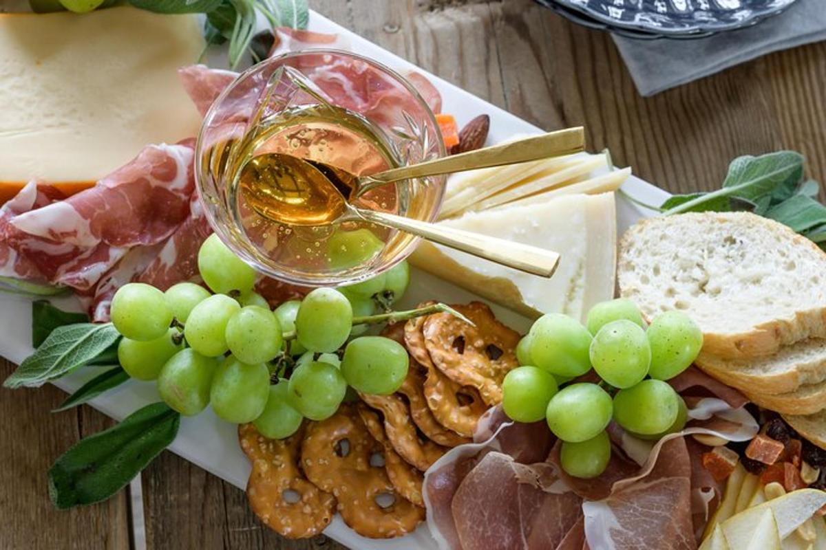 a plate of food with a glass of wine and grapes