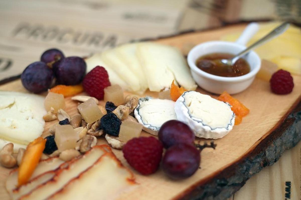 un piatto di cibo con formaggio, frutta e una salsa