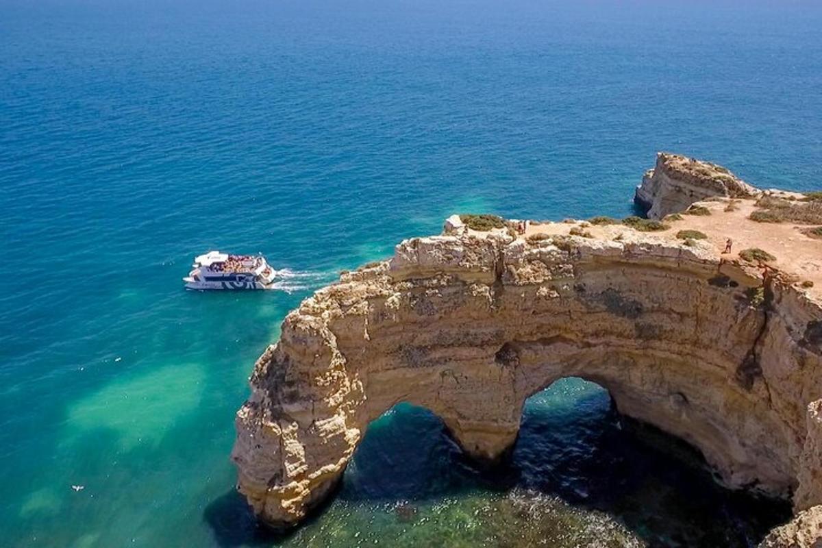 una barca in acqua accanto a una scogliera rocciosa