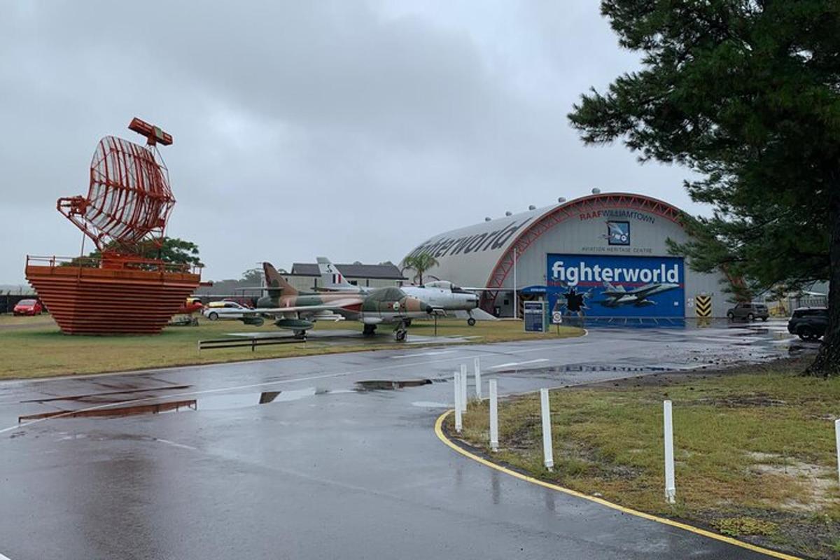 un aeroporto con un aereo parcheggiato davanti a un hangar