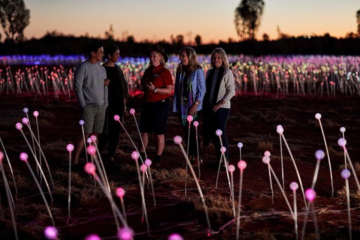 a group of people standing in a field of flowers