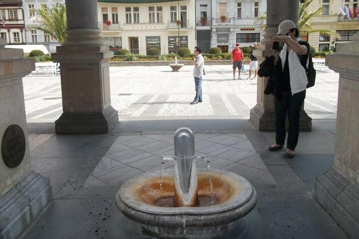 egy nő fényképez egy szökőkutat az udvaron