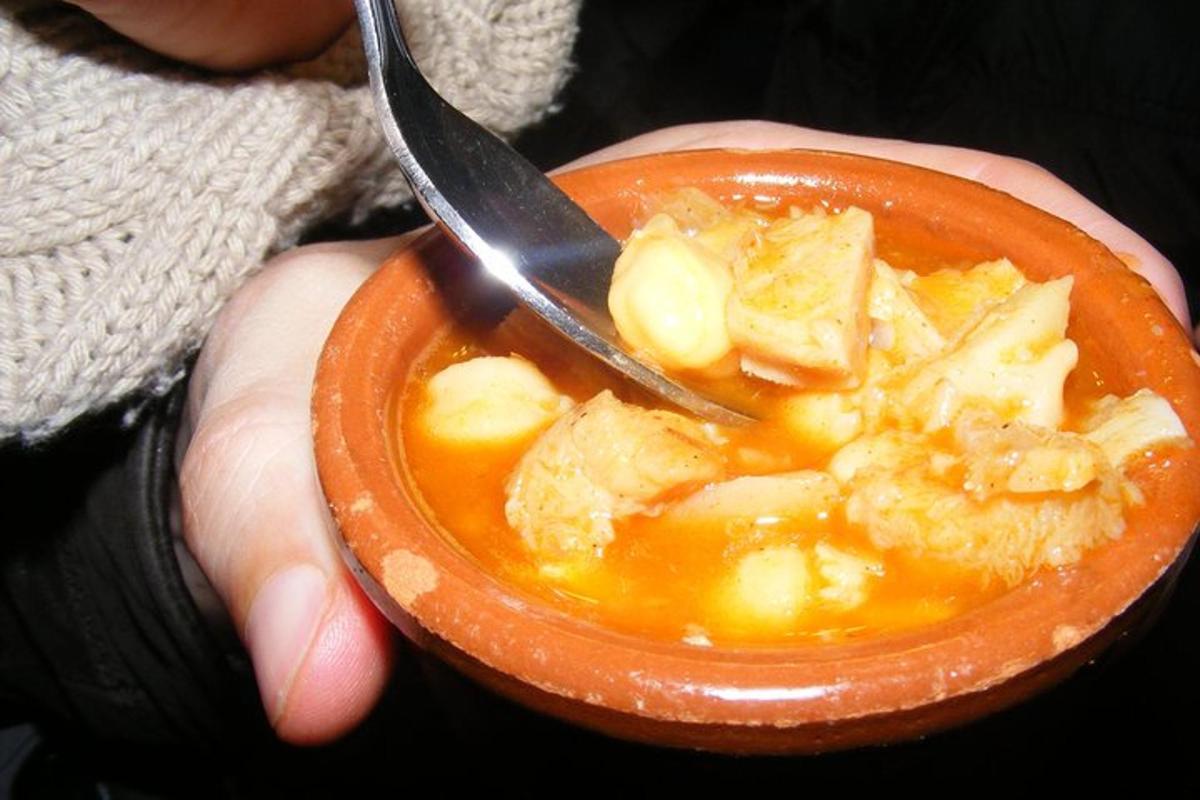 una persona che tiene una ciotola di zuppa con un cucchiaio