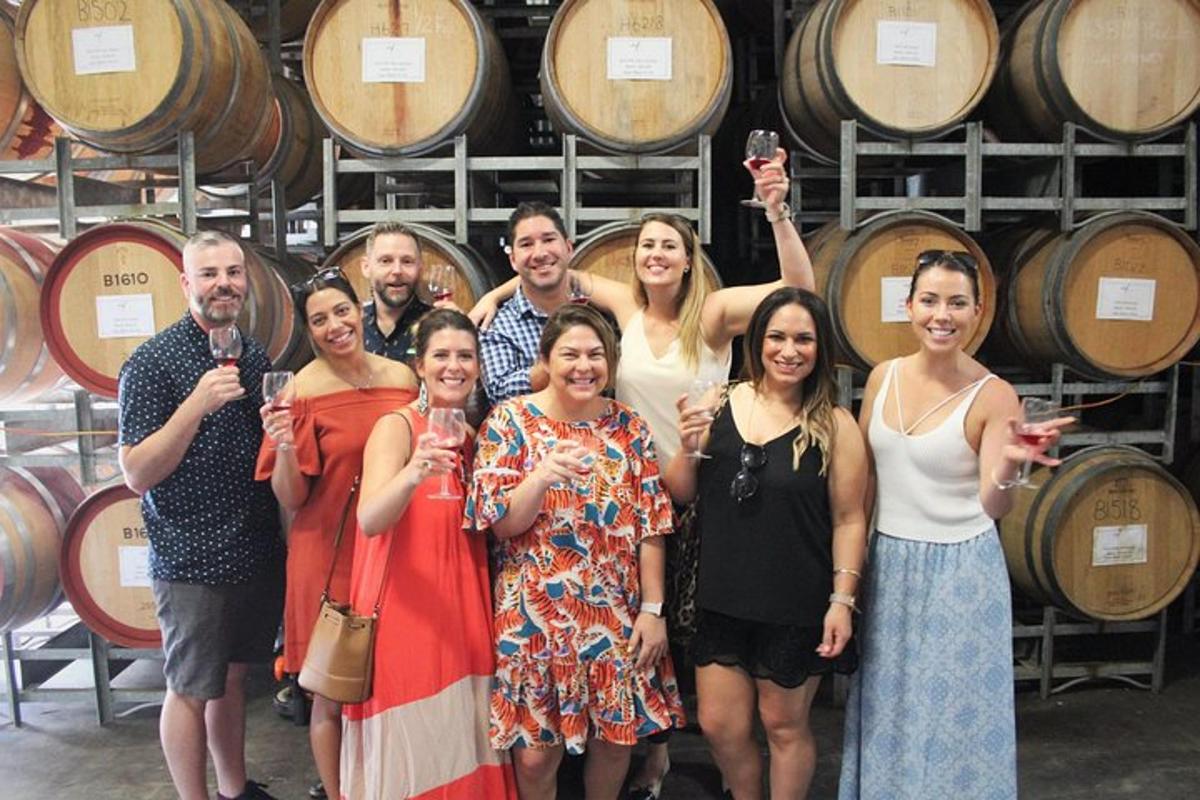 a group of people standing in front of wine barrels