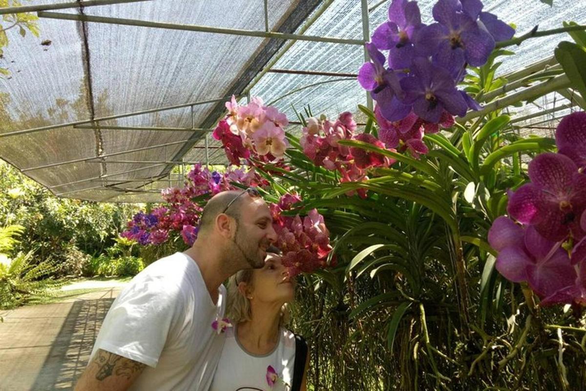 um homem e uma mulher se beijando em frente às flores