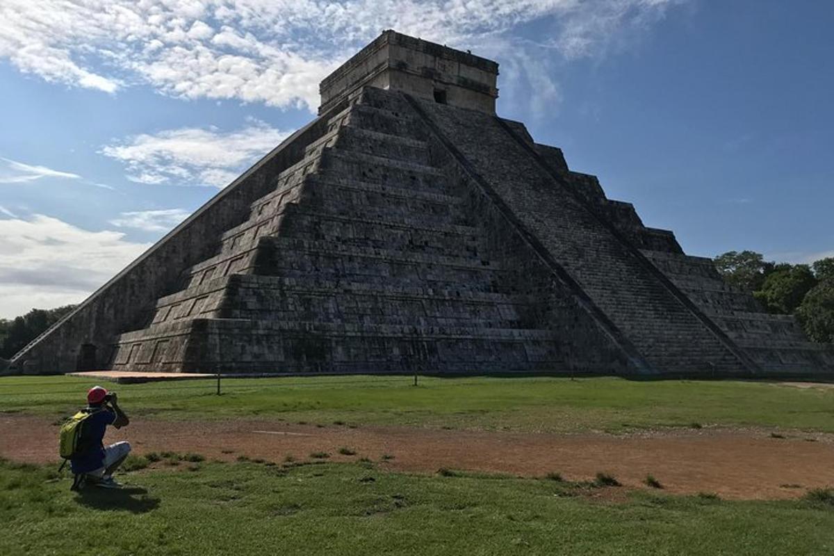 osoba dřepící před pyramidou