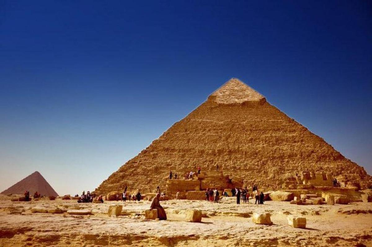 en gruppe mennesker som står foran pyramiden