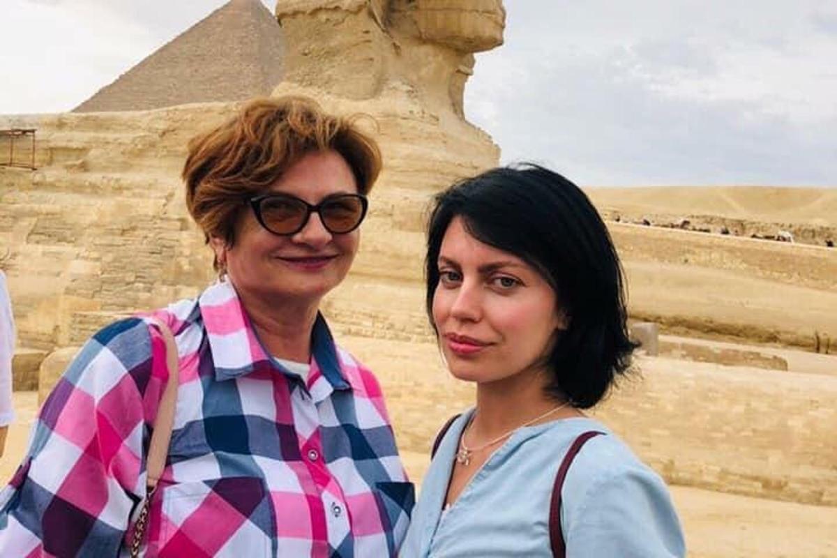 two women standing in front of the pyramids