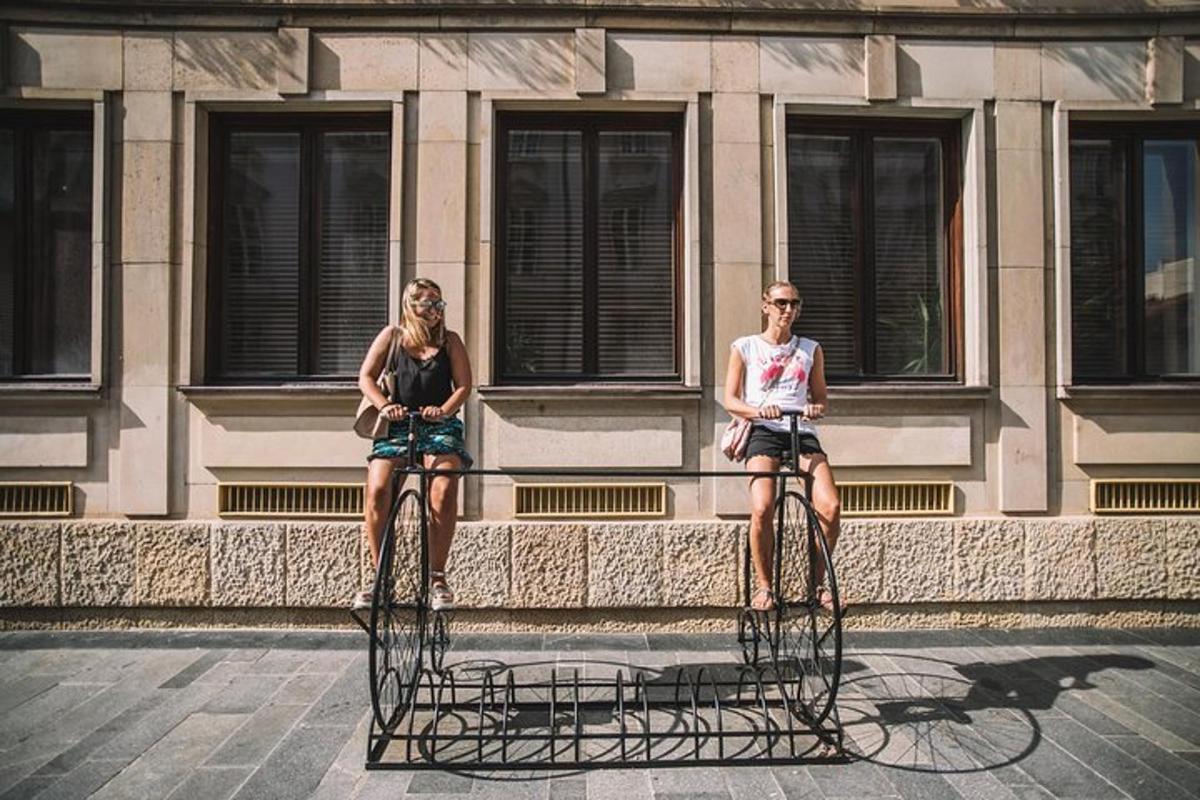 two women sitting on bikes in front of a building
