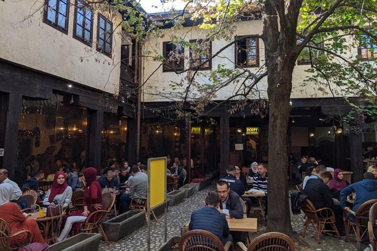 eine Gruppe von Menschen, die an Tischen vor einem Restaurant sitzen
