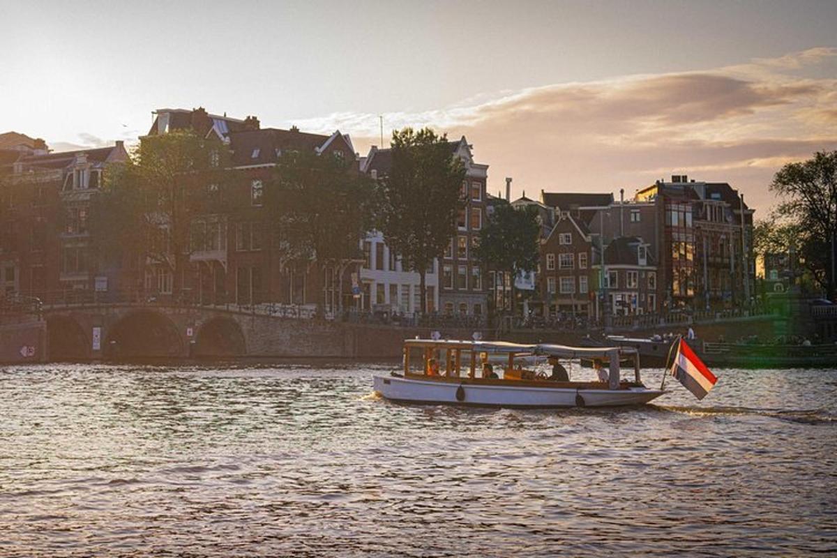 a boat with a flag on a river with buildings