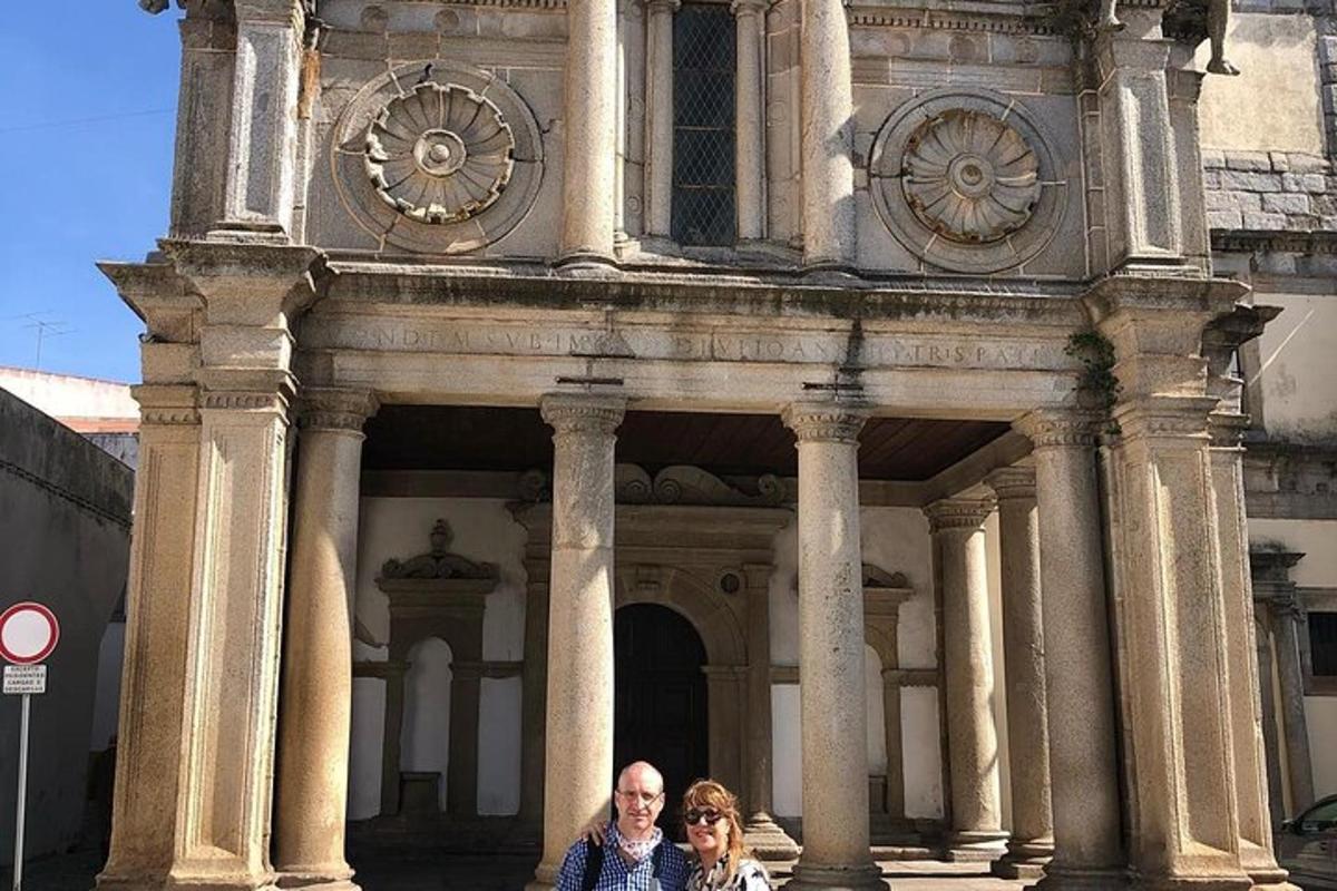 due persone in piedi davanti a un edificio con un orologio