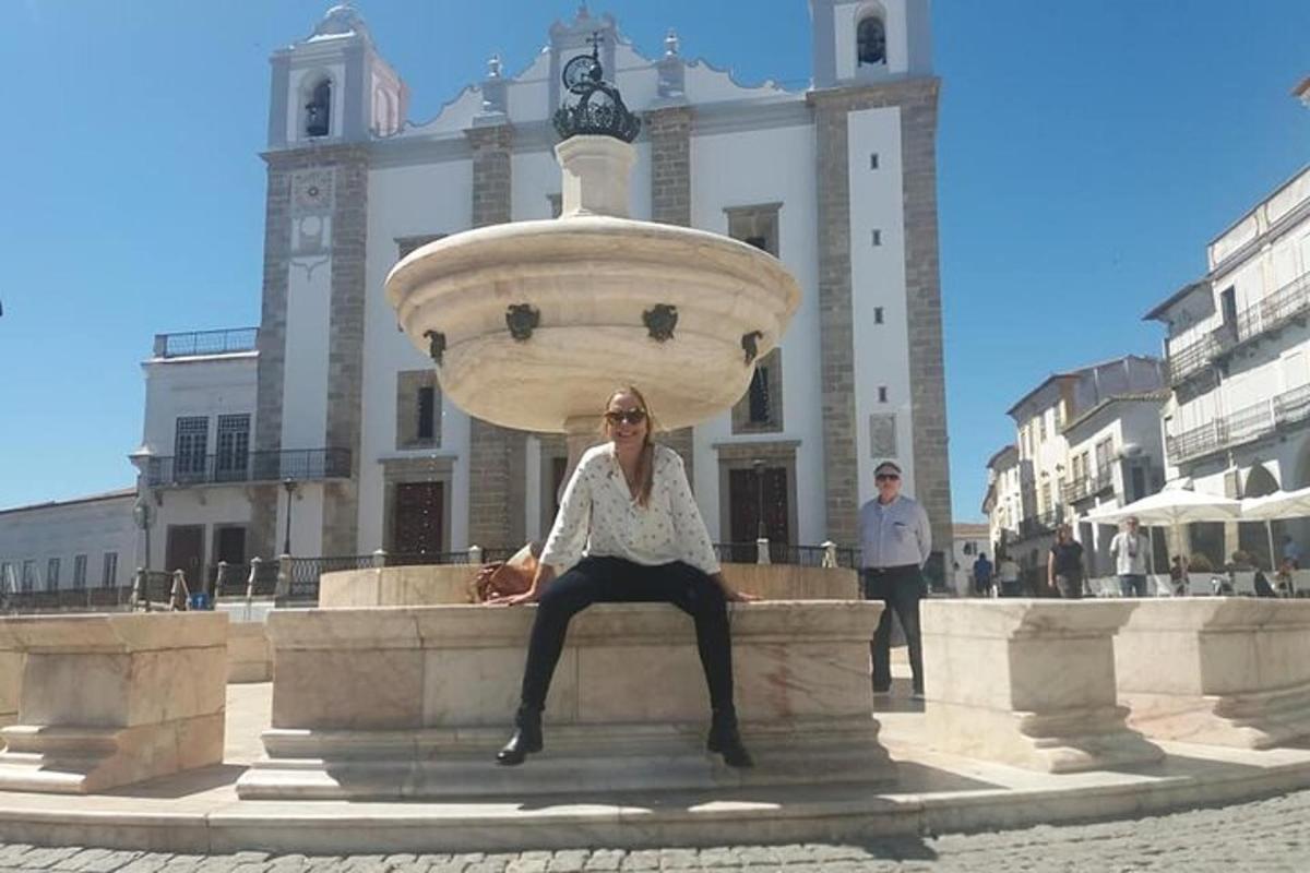 una donna seduta su una fontana di fronte a un edificio