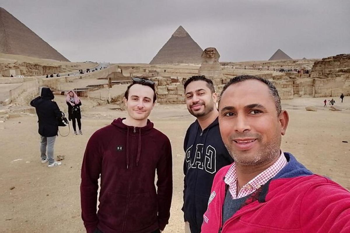 três homens em pé em frente às pirâmides