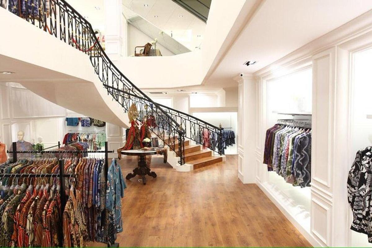 a hallway with a staircase and a clothing store