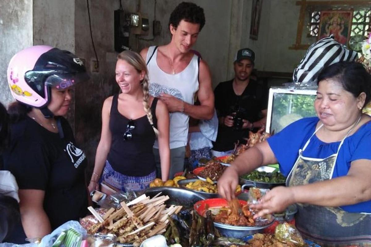 un gruppo di persone in piedi attorno a un buffet di cibo