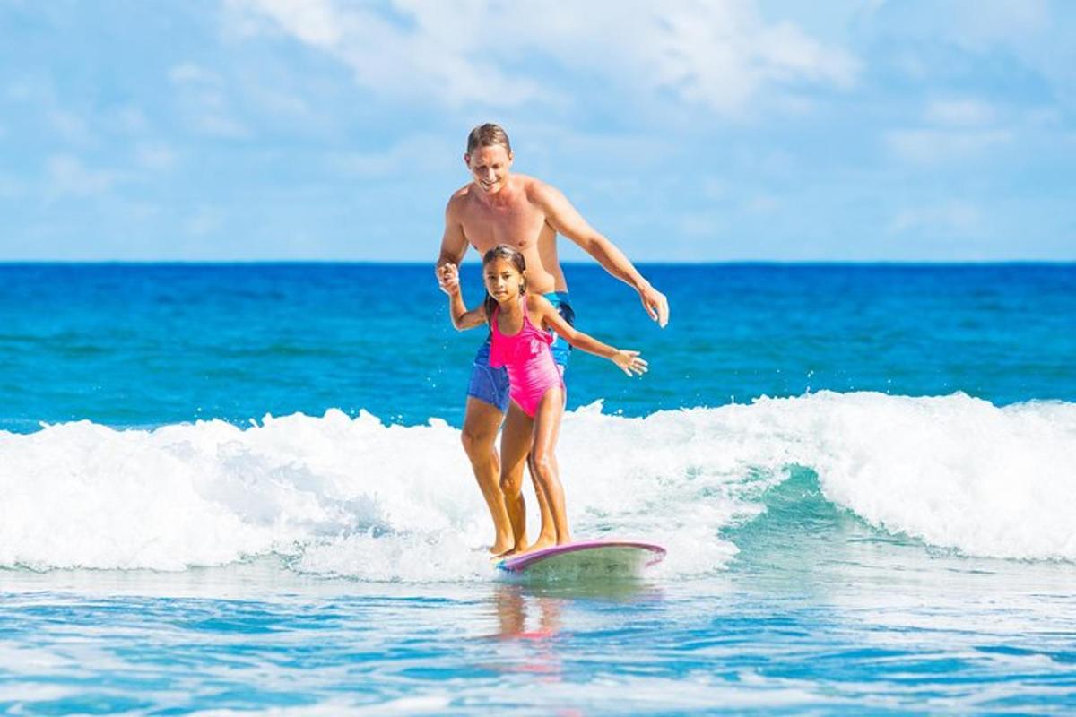 un uomo e una ragazza cavalcano un'onda su una tavola da surf