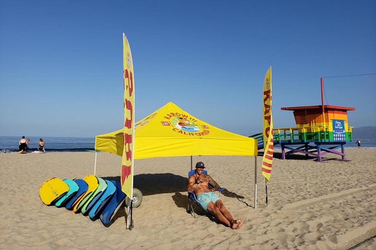 un uomo seduto sotto una tenda sulla spiaggia