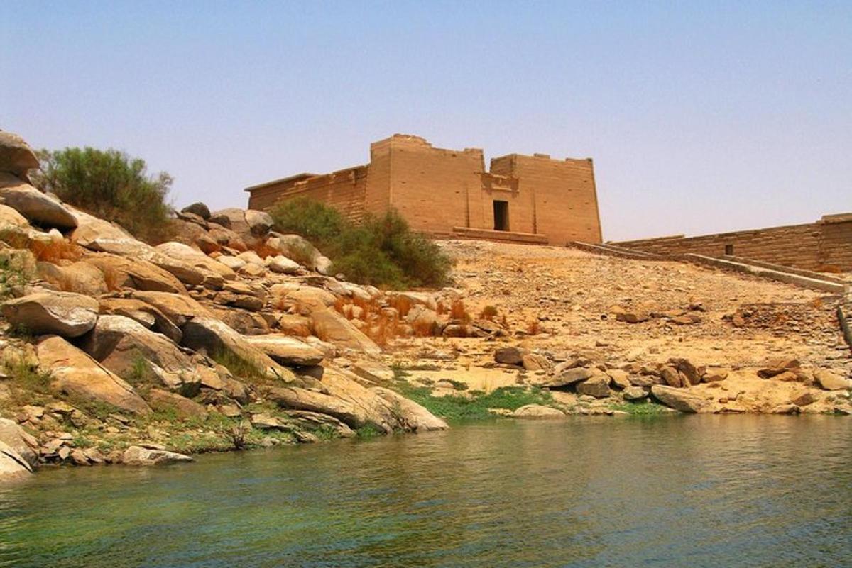 un edificio su una collina rocciosa accanto a un fiume